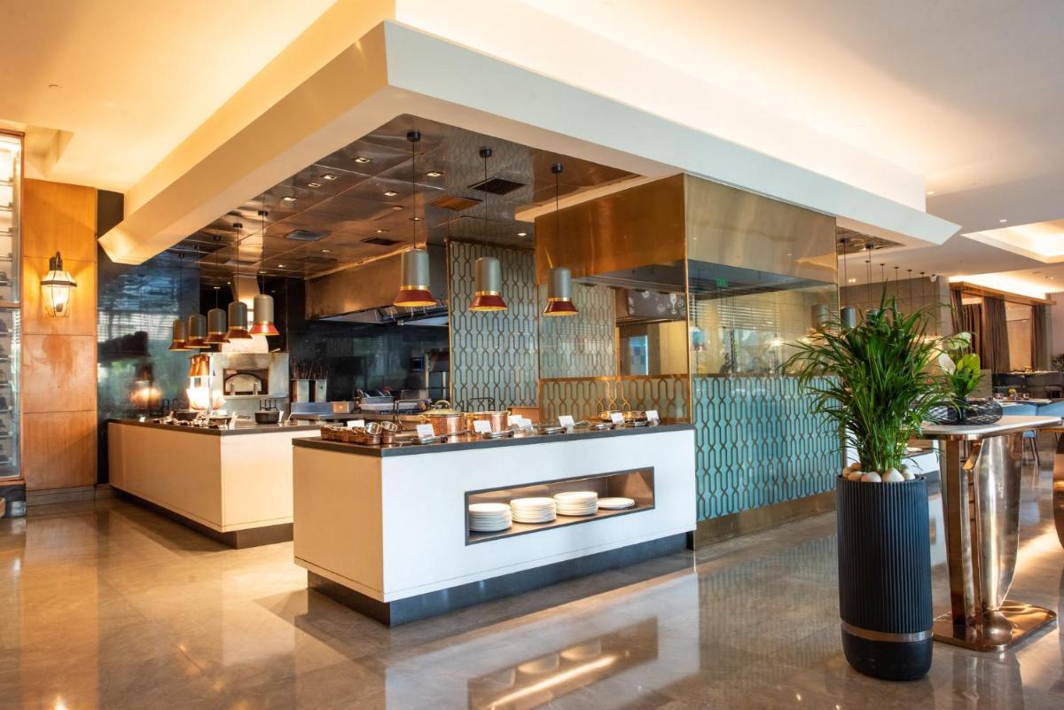 a restaurant kitchen with a counter with food at Crowne Plaza Today Gurugram by IHG in Gurgaon