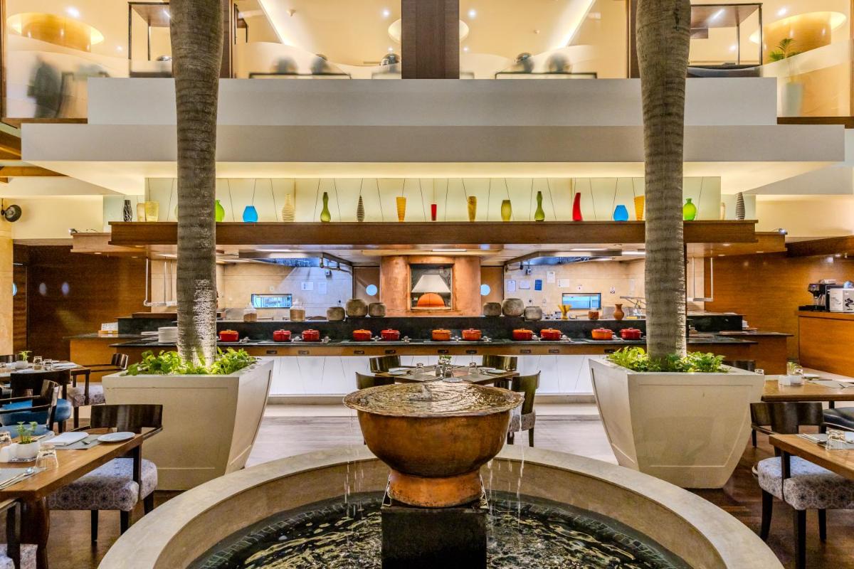 a restaurant with a fountain in the middle at Vivanta Goa, Panaji in Panaji a restaurant with a fountain in the middle at Vivanta Goa, Panaji in Panaji