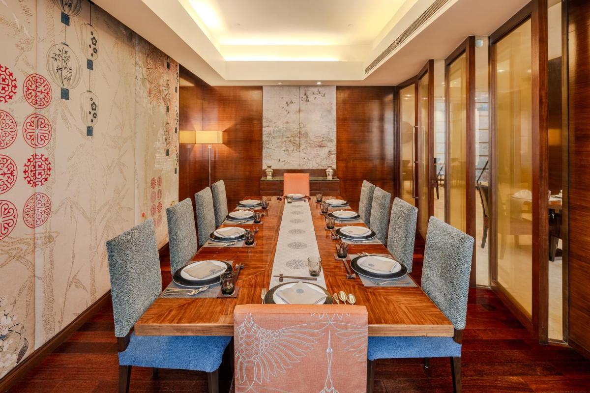 a long dining room with a long table and chairs at Vivanta Goa, Panaji in Panaji a long dining room with a long table and chairs at Vivanta Goa, Panaji in Panaji