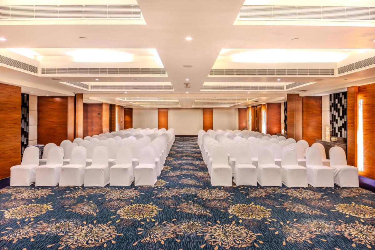 an empty conference room with white chairs in it at Vivanta Goa, Panaji in Panaji an empty conference room with white chairs in it at Vivanta Goa, Panaji in Panaji