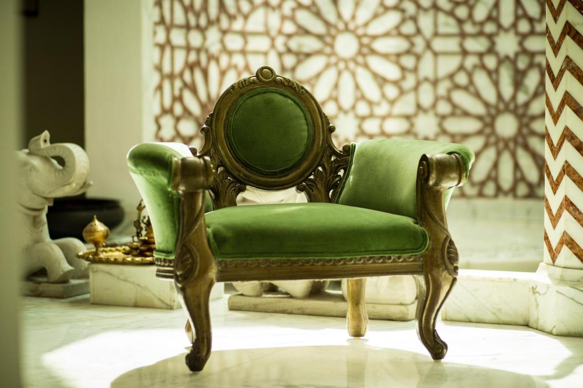a green chair sitting in a living room at The Imperial, New Delhi in New Delhi a green chair sitting in a living room at The Imperial, New Delhi in New Delhi