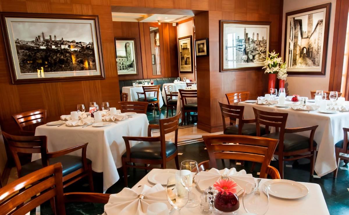 a restaurant with tables and chairs with white tablecloths at The Imperial, New Delhi in New Delhi a restaurant with tables and chairs with white tablecloths at The Imperial, New Delhi in New Delhi