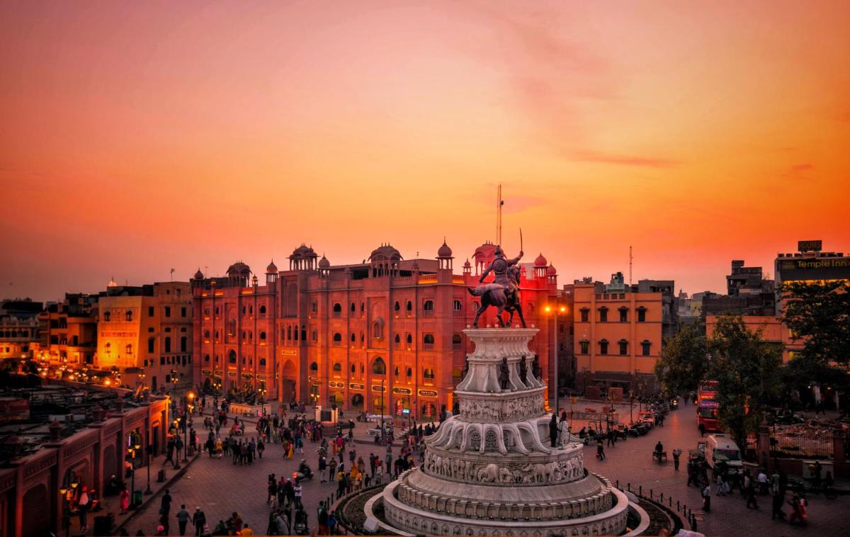 a statue in the middle of a city at sunset at Courtyard by Marriott Amritsar in Amritsar