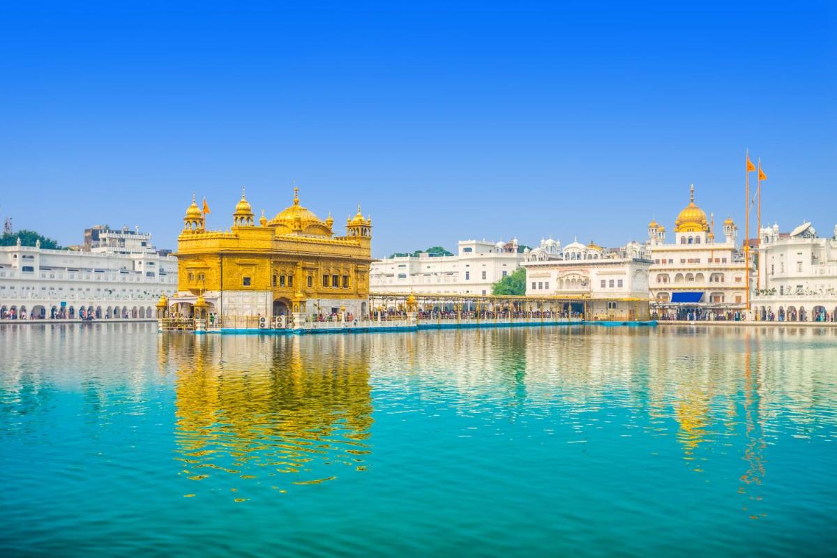 a view of the amritsar golden temple with its reflection in water at Courtyard by Marriott Amritsar in Amritsar
