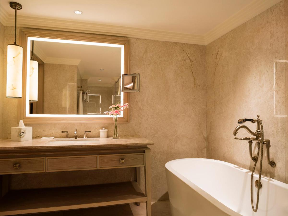a bathroom with a tub and a sink and a mirror at Taj Ganges Varanasi in Varanasi