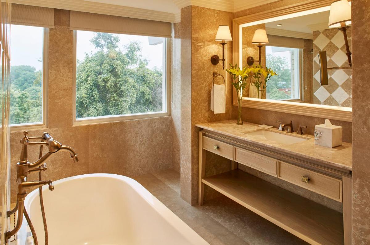 a bathroom with a tub and a sink and a mirror at Taj Ganges Varanasi in Varanasi