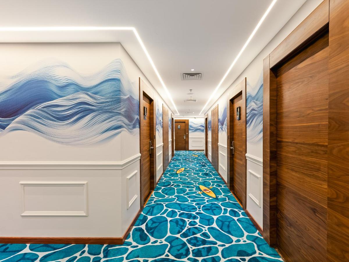 a hallway with a mural of the ocean on the wall at Gateway Goa, Palolem in Palolem