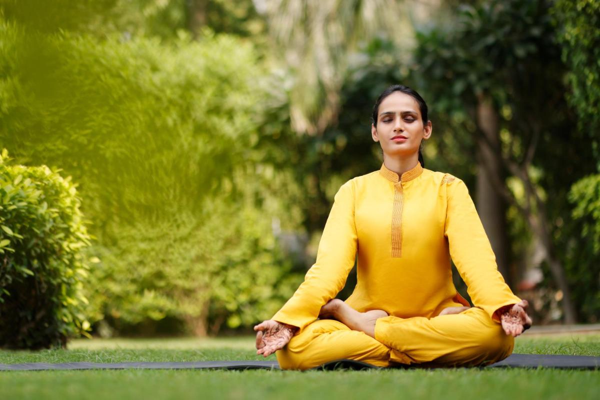 a woman sitting in a yoga pose in the grass at The Imperial, New Delhi in New Delhi a woman sitting in a yoga pose in the grass at The Imperial, New Delhi in New Delhi