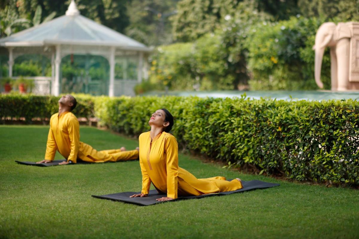 two people sitting in the grass doing yoga at The Imperial, New Delhi in New Delhi two people sitting in the grass doing yoga at The Imperial, New Delhi in New Delhi