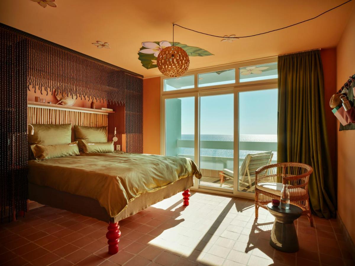 Un dormitorio con una cama y una ventana grande. en Bikini Island & Mountain Hotel Es Trenc -Adults only-, en Colonia de Sant Jordi