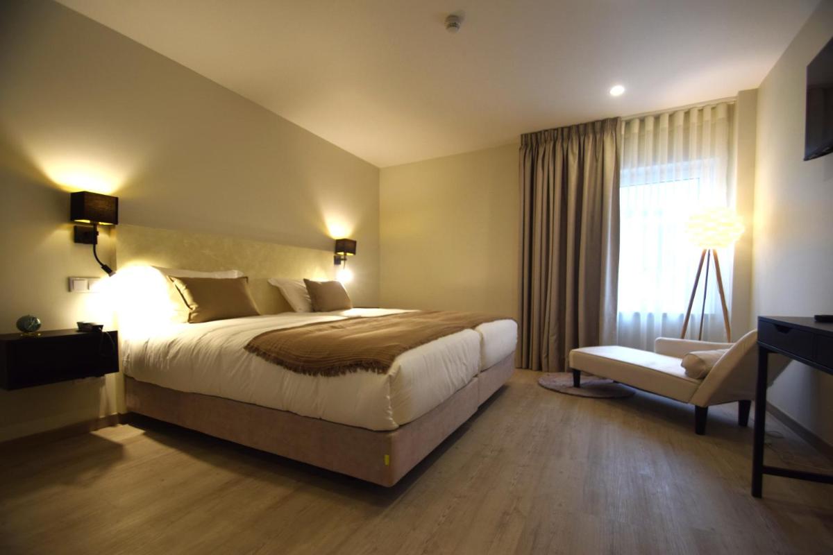 um quarto de hotel com uma cama e uma janela em SIENNA Hotel em Rio Maior