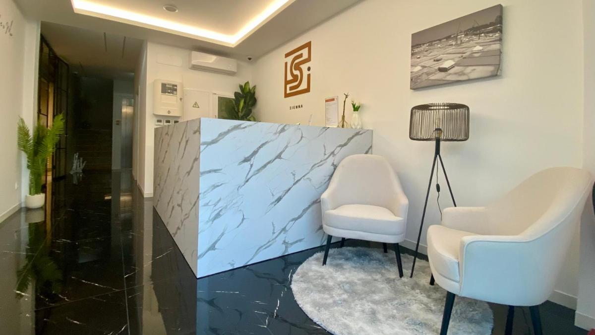 um salão com duas cadeiras brancas e um espelho em SIENNA Hotel em Rio Maior