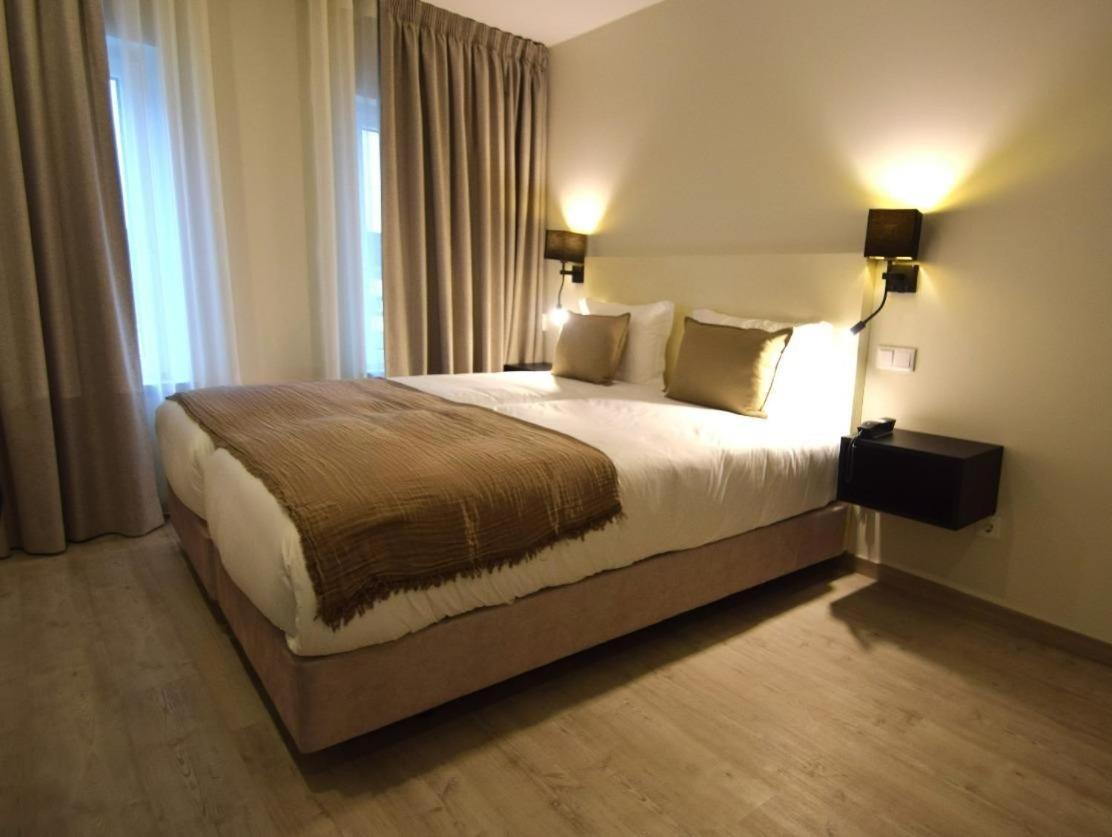 um quarto com uma cama grande em um quarto de hotel em SIENNA Hotel em Rio Maior