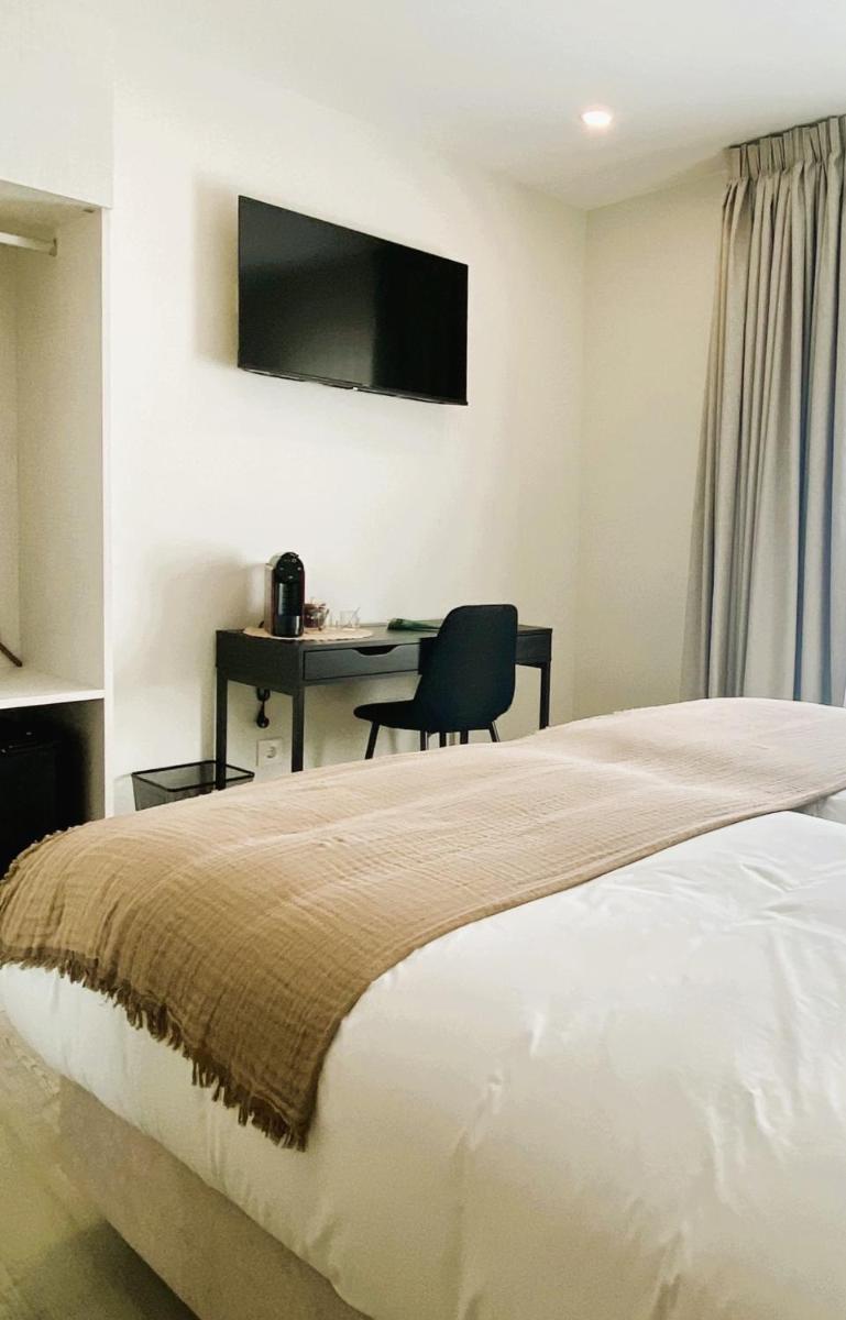 um quarto com uma cama e uma escrivaninha com uma cadeira em SIENNA Hotel em Rio Maior mais 15 fotografias