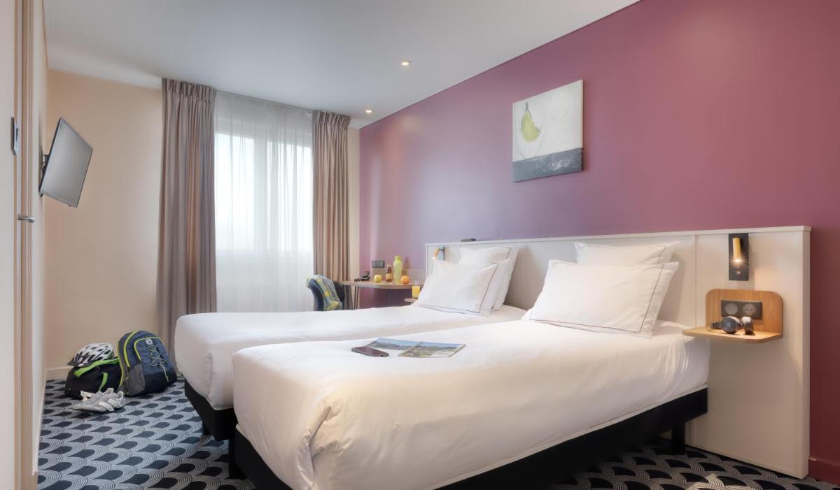 Un ou plusieurs lits dans un hébergement de l'établissement Brit Hotel Les Voyageurs