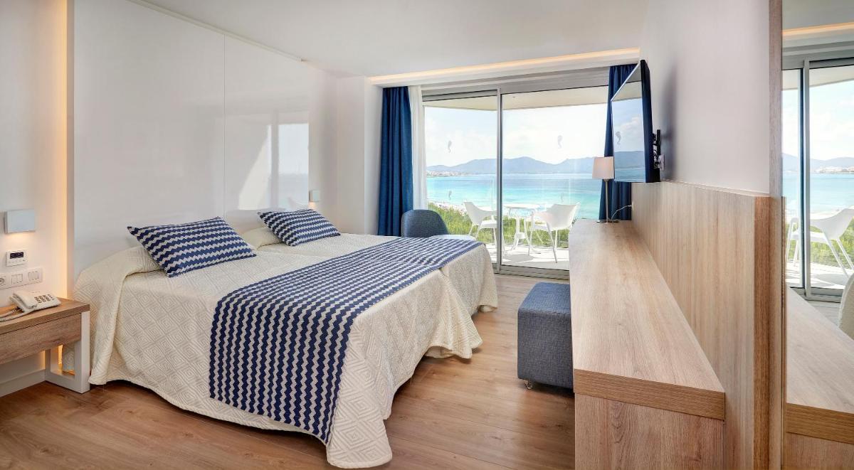 Un dormitorio con una cama y vista al mar. en Hipotels Bahia Cala Millor - Adults Only, en Cala Millor