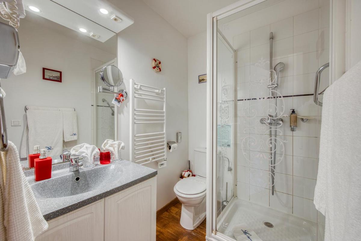 une salle de bain avec une douche, un lavabo et des toilettes dans l'établissement Les Cygnes, à Évian-les-Bains