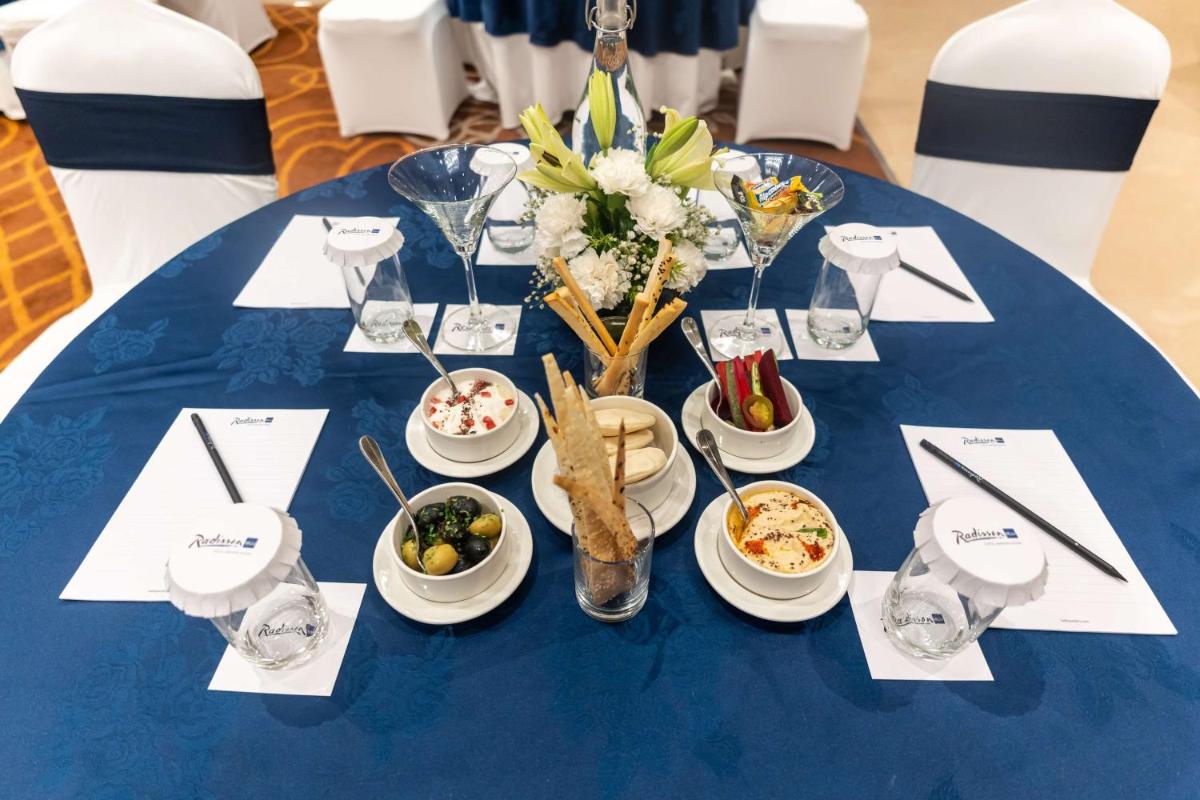 a blue table with plates of food on it at Radisson Blu Hotel, Greater Noida in Greater Noida
