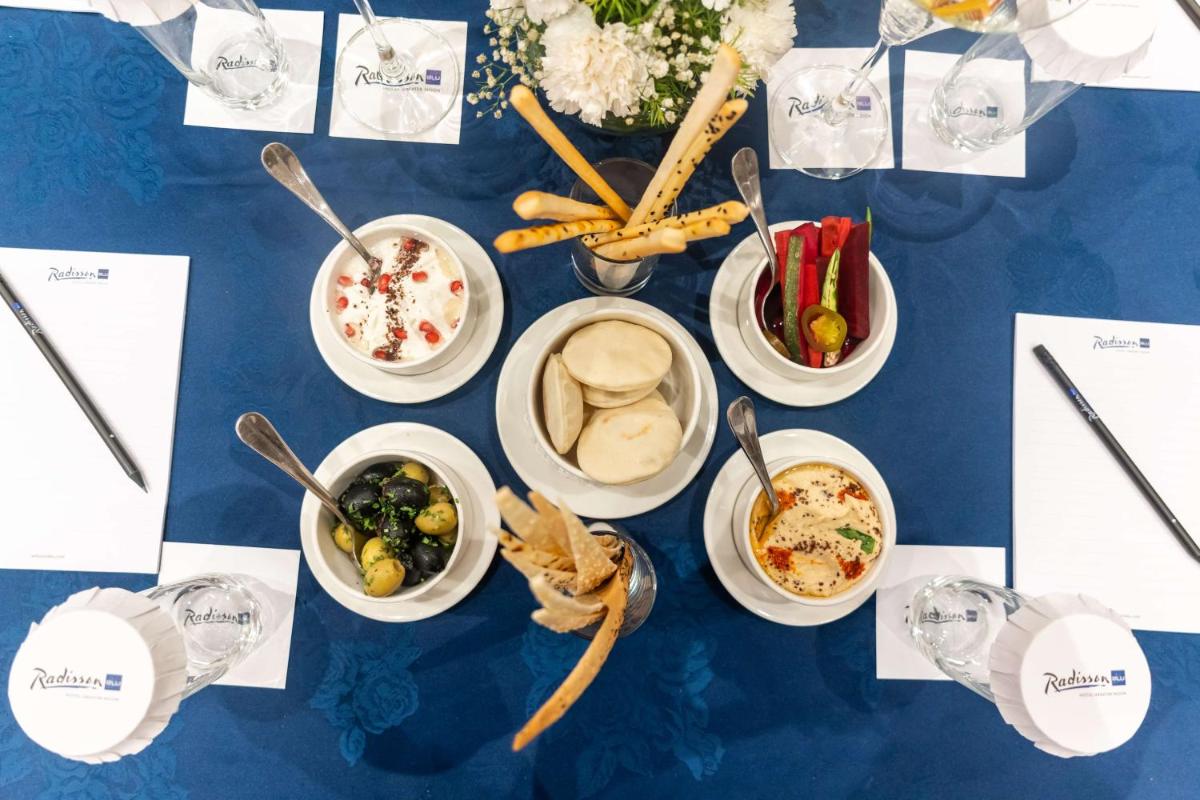 a blue table with bowls of food on it at Radisson Blu Hotel, Greater Noida in Greater Noida