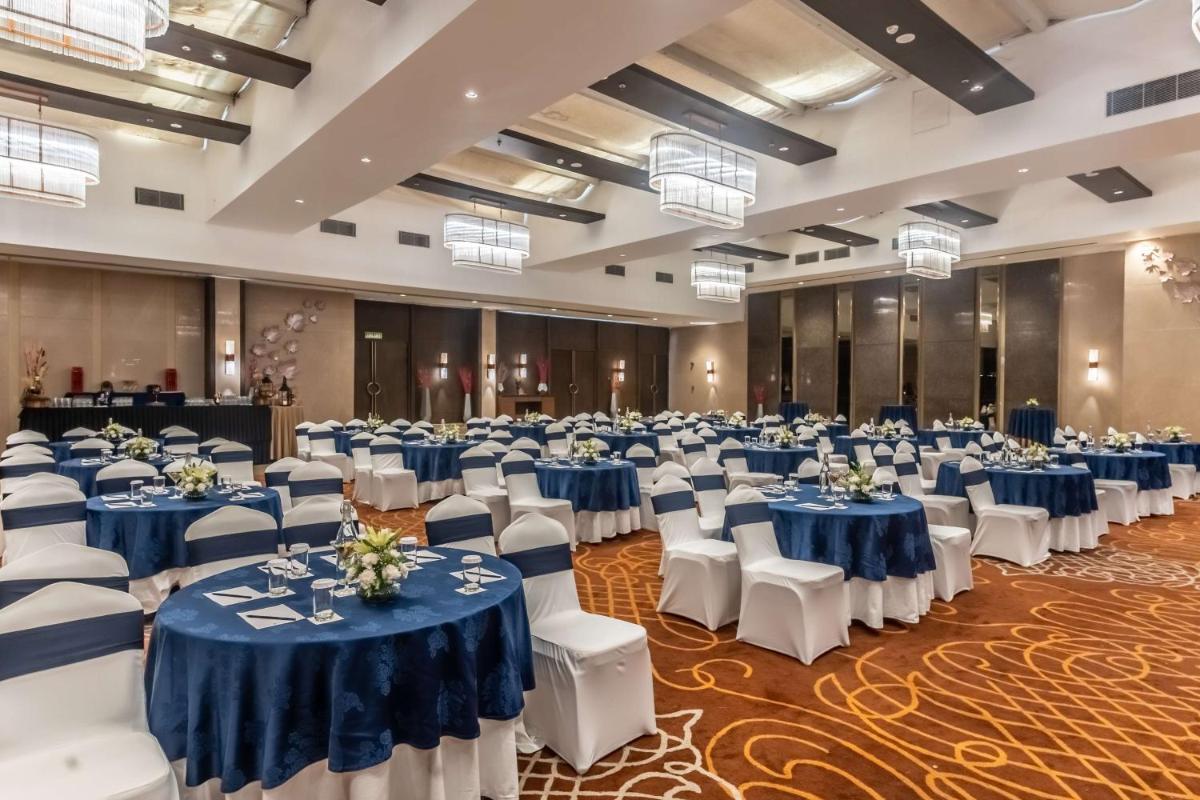 a large banquet hall with blue and white tables and chairs at Radisson Blu Hotel, Greater Noida in Greater Noida