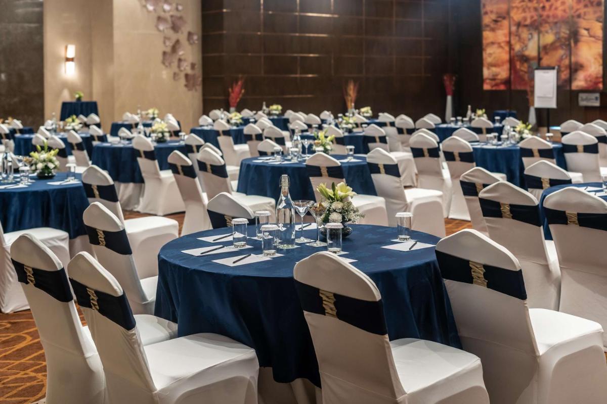 a group of tables and chairs in a banquet hall at Radisson Blu Hotel, Greater Noida in Greater Noida