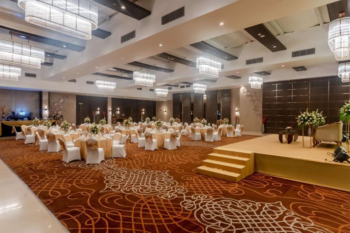 a large banquet hall with white tables and chairs at Radisson Blu Hotel, Greater Noida in Greater Noida