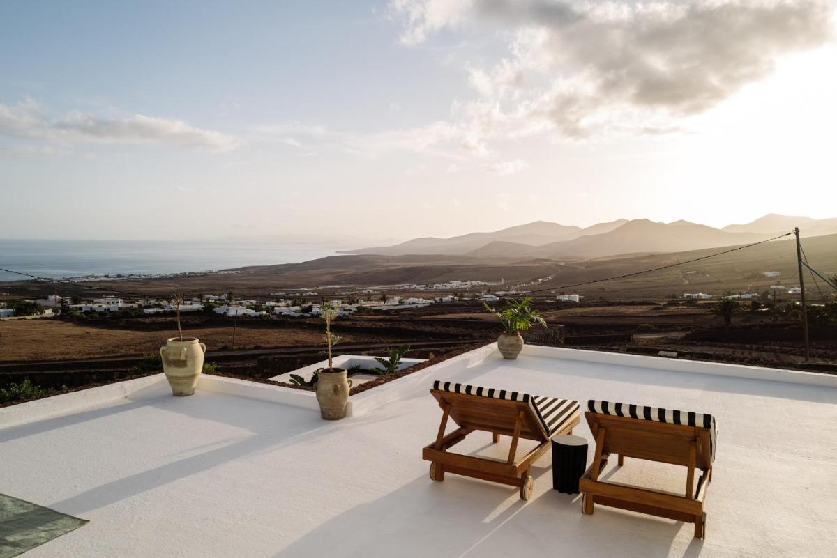 Un balcón con dos sillas y vista al mar. en César Lanzarote Luxury Boutique Hotel - Adults Only, en La Asomada