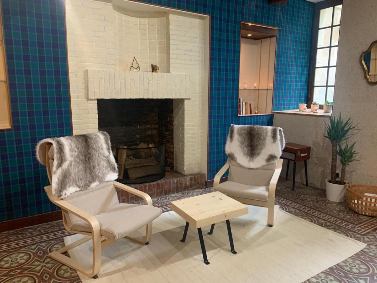 un salon avec deux chaises et une cheminée dans l'établissement Château de Noizay - ChâteauZen, à Noizay