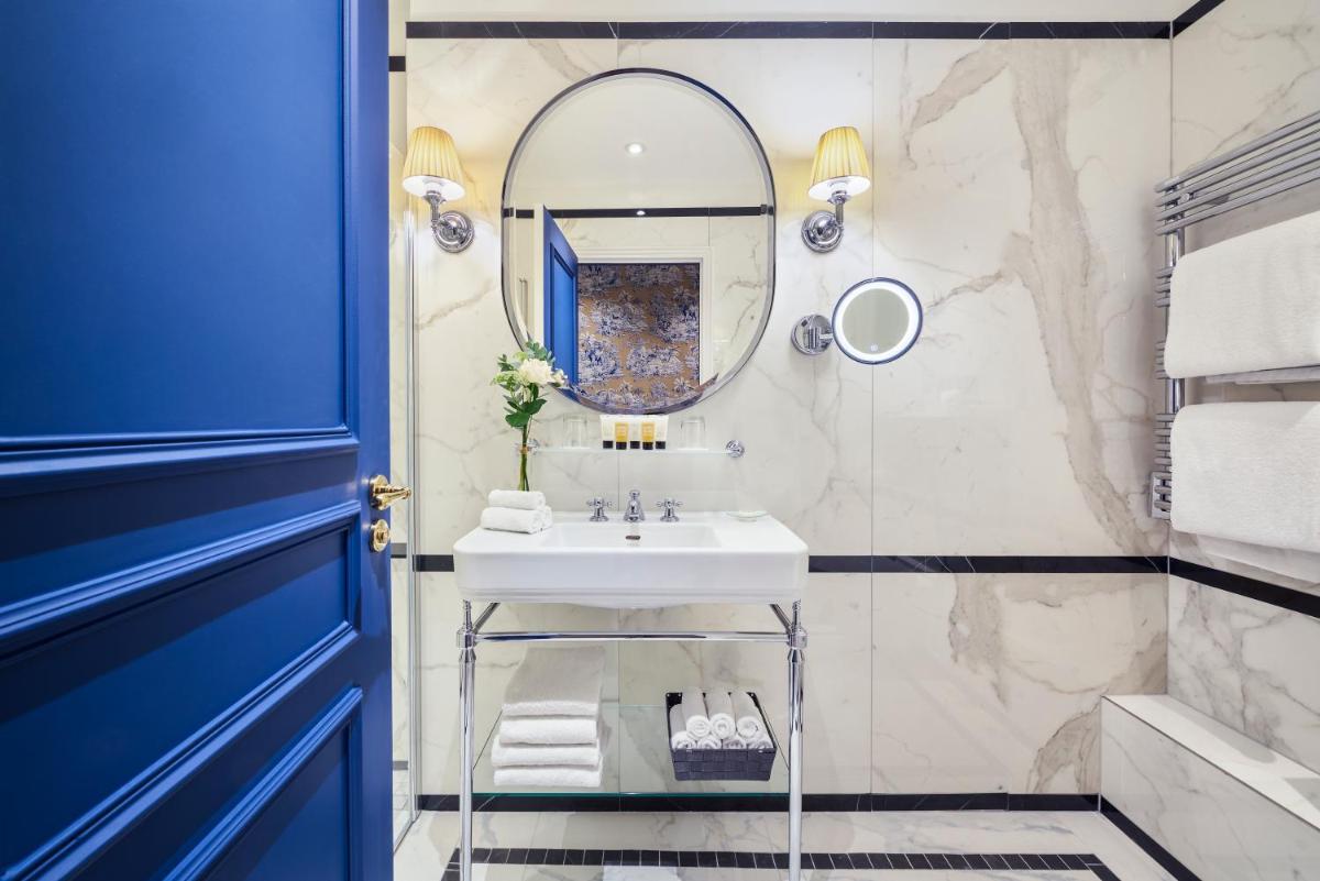 une salle de bain avec un lavabo et un miroir dans l'établissement Hotel Westminster, à Paris 37 autres photos