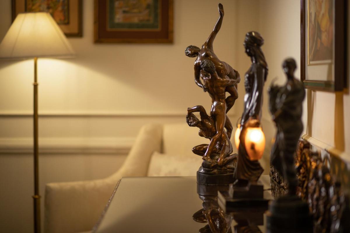 a table with a lamp and a statue of two people at The Imperial, New Delhi in New Delhi a table with a lamp and a statue of two people at The Imperial, New Delhi in New Delhi