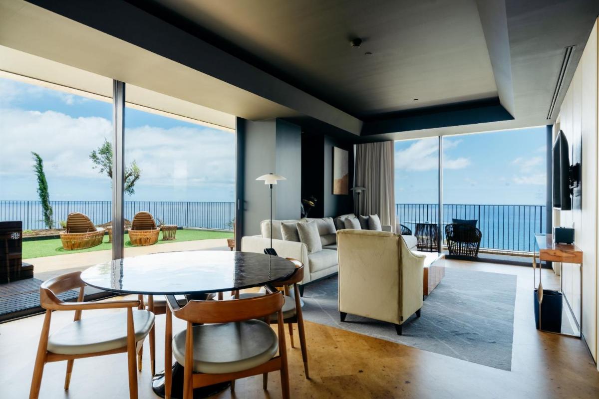 uma sala de estar com mesa e cadeiras em The Reserve - within Savoy Palace - The Leading Hotels of the World no Funchal