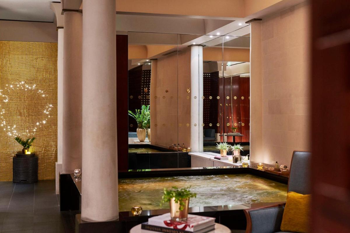 - un hall avec un grand miroir et une piscine dans l'établissement Park Hyatt Paris - Vendôme, à Paris