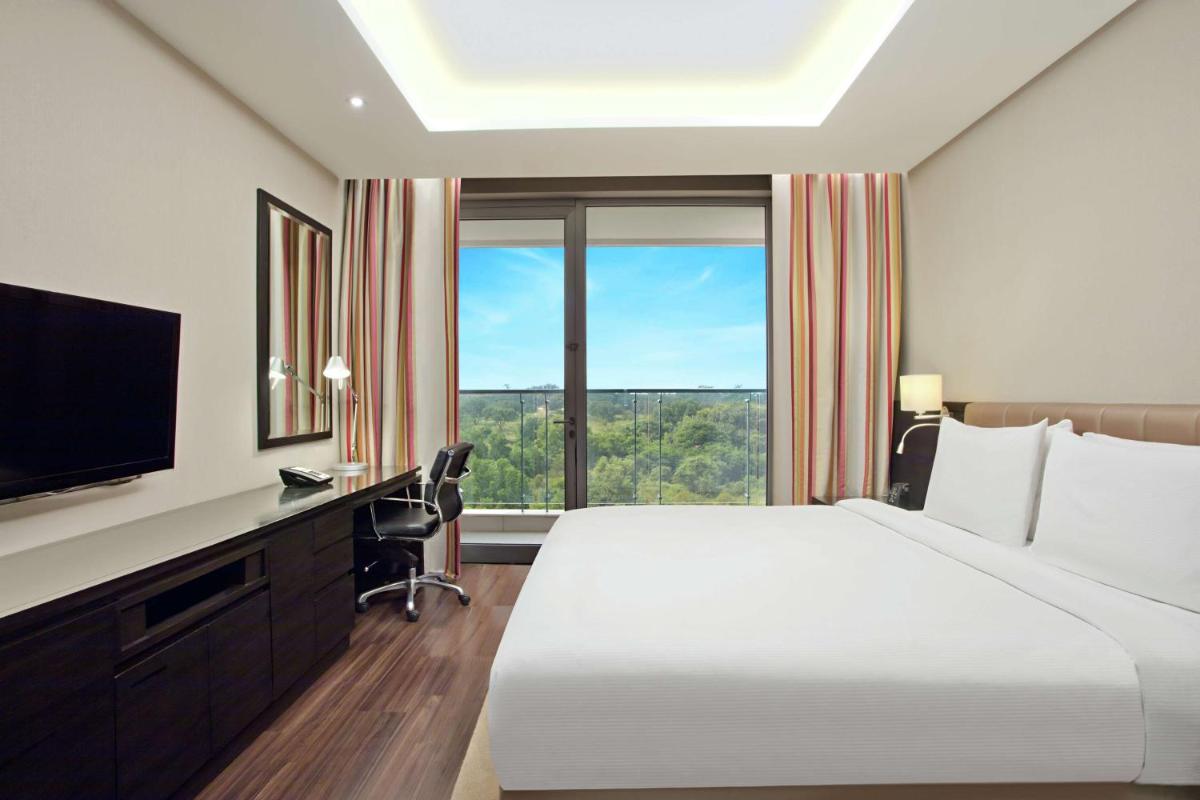 a hotel room with a bed and a large window at DoubleTree Suites by Hilton Bengaluru Outer Ring Road in Bengaluru
