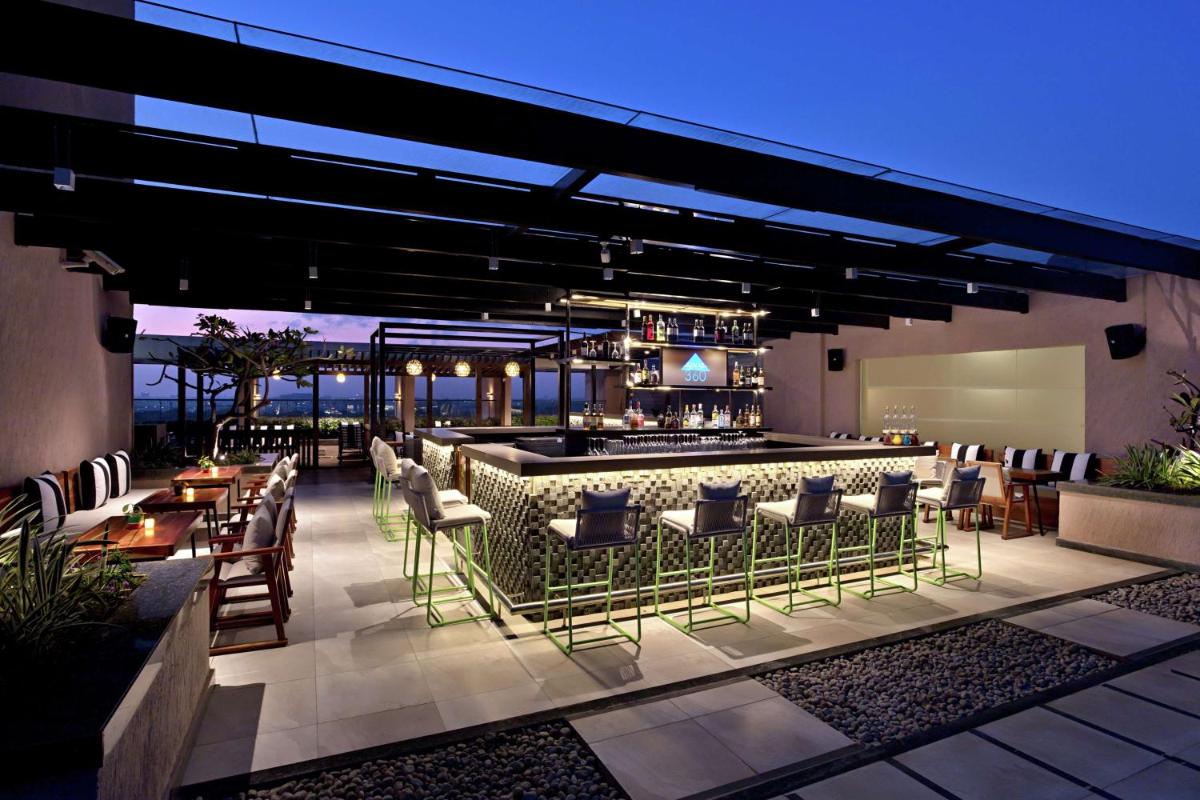 a patio with a bar with chairs and tables at DoubleTree Suites by Hilton Bengaluru Outer Ring Road in Bengaluru