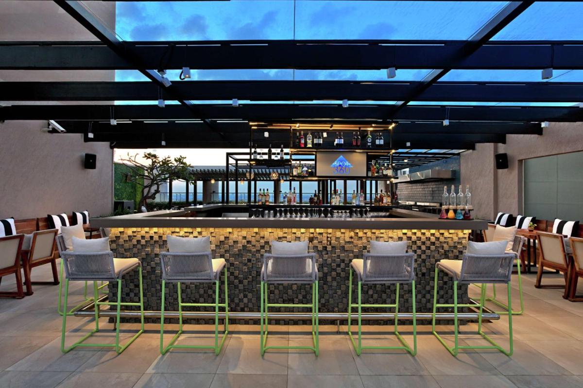 a bar with a bunch of chairs and a counter at DoubleTree Suites by Hilton Bengaluru Outer Ring Road in Bengaluru