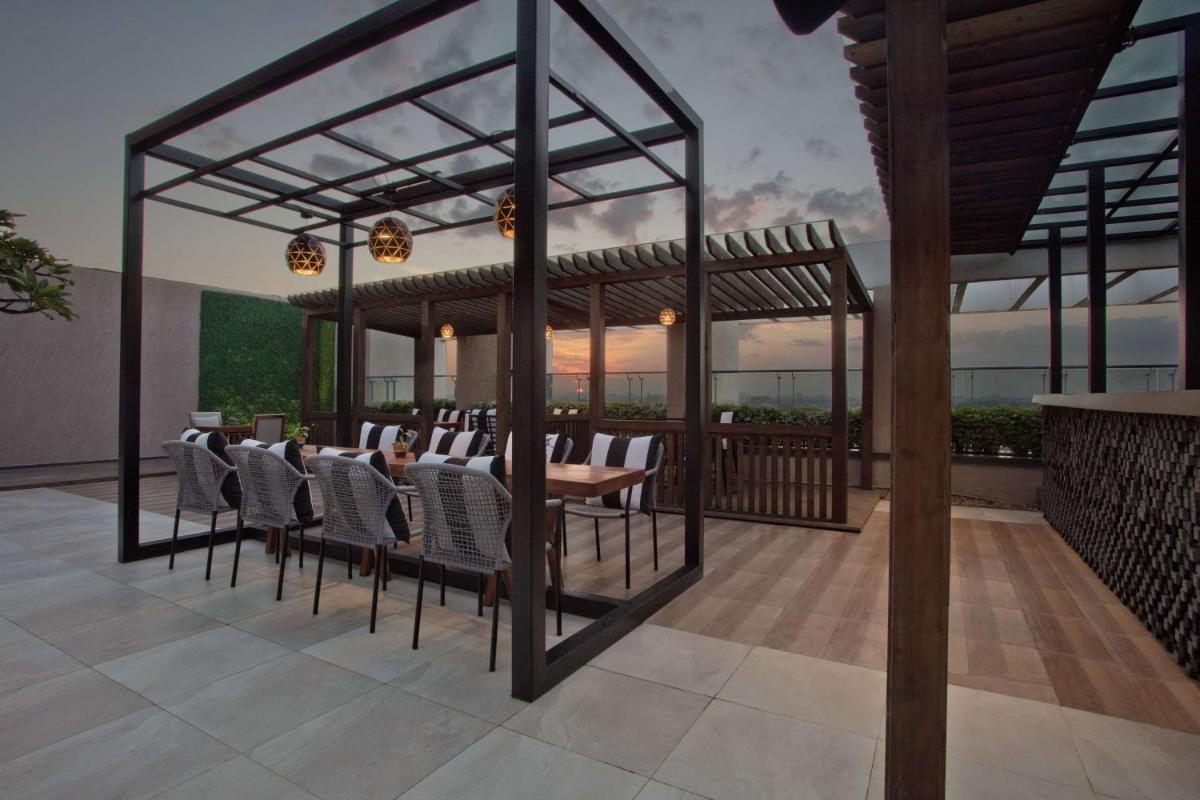 a rendering of a patio with a table and chairs at DoubleTree Suites by Hilton Bengaluru Outer Ring Road in Bengaluru