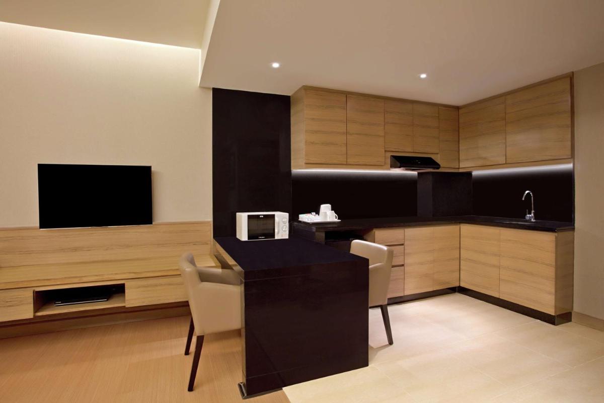 a kitchen with a table and chairs and a television at DoubleTree Suites by Hilton Bengaluru Outer Ring Road in Bengaluru