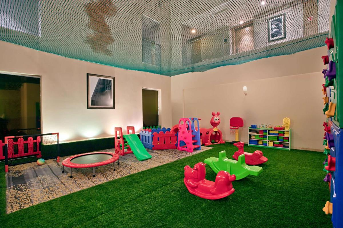 a room with a play area with green grass at DoubleTree Suites by Hilton Bengaluru Outer Ring Road in Bengaluru