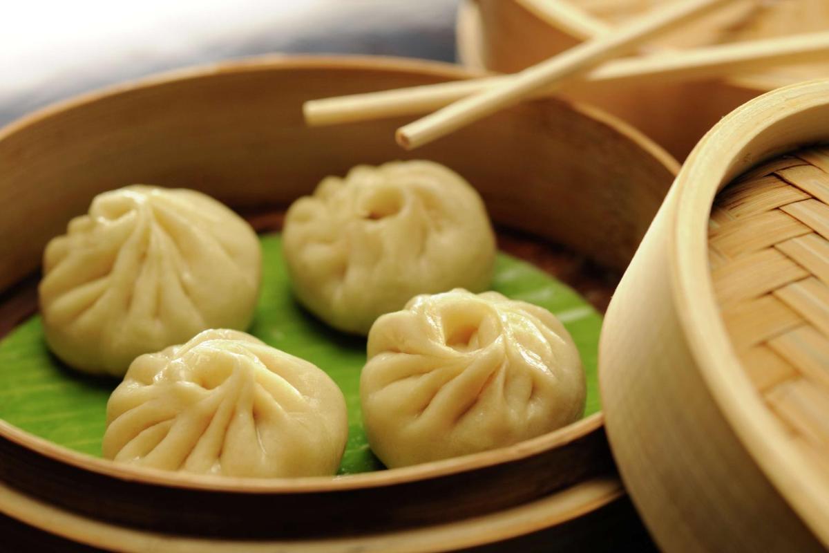 a group of dumplings on a green plate with chopsticks at DoubleTree by Hilton Gurgaon New Delhi NCR in Gurgaon