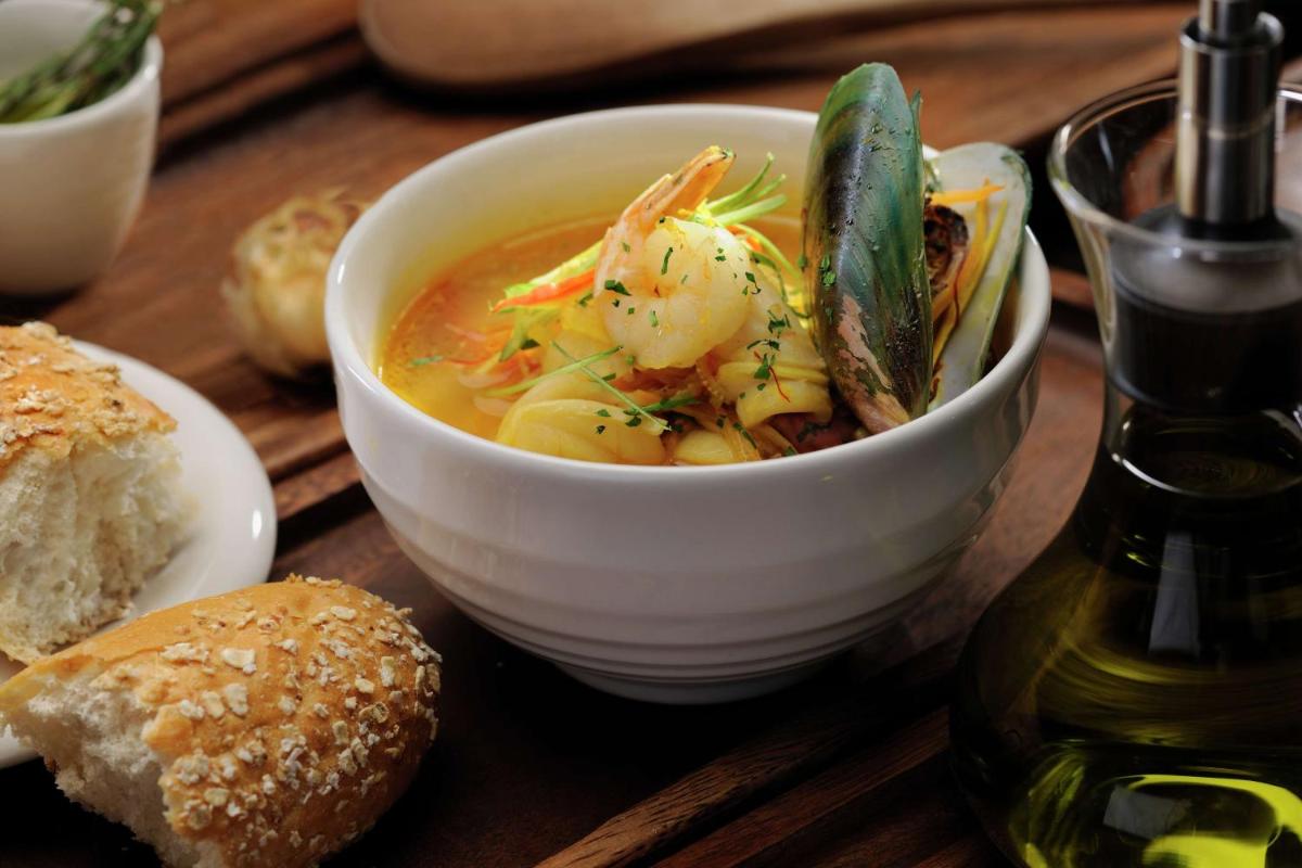 a bowl of soup on a wooden table with bread at DoubleTree by Hilton Gurgaon New Delhi NCR in Gurgaon +64 photos