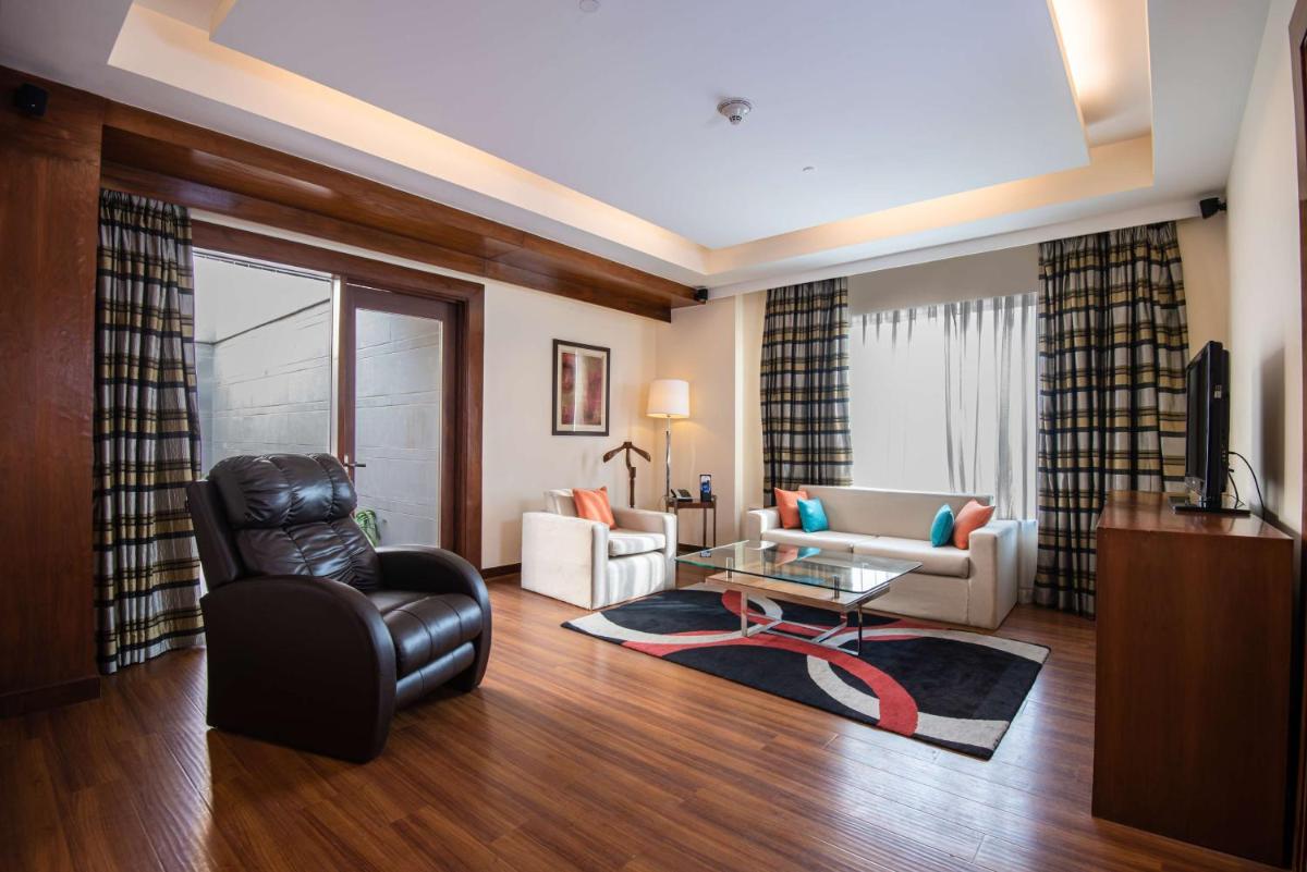 a living room with a black leather chair and a table at DoubleTree by Hilton Gurgaon New Delhi NCR in Gurgaon
