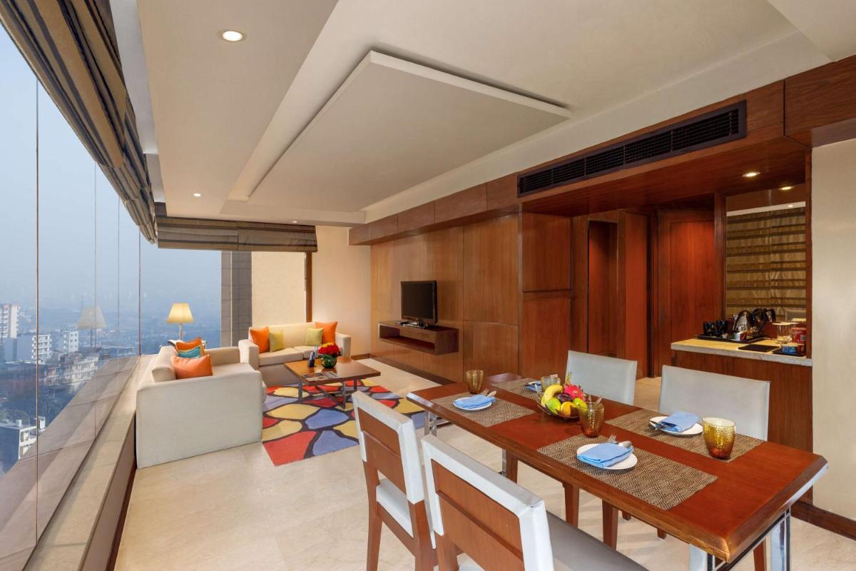 a kitchen and living room with a table and chairs at DoubleTree by Hilton Gurgaon New Delhi NCR in Gurgaon