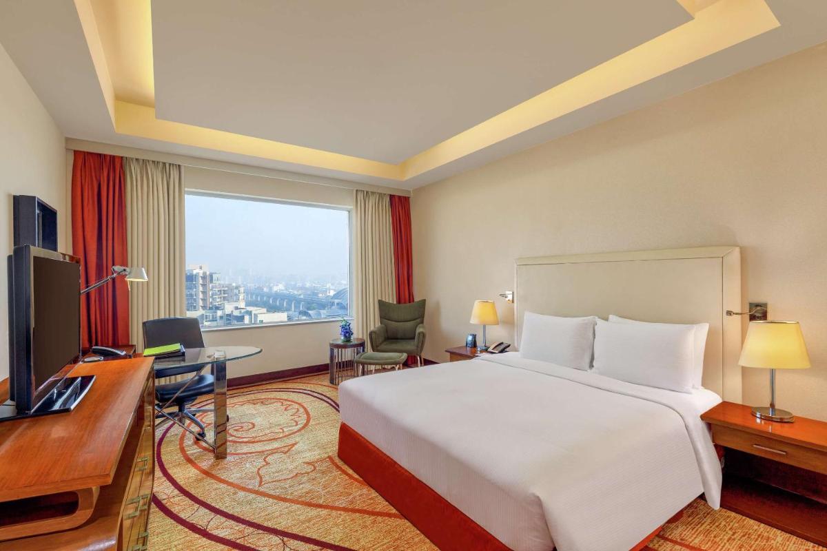 a hotel room with a large bed and a desk at DoubleTree by Hilton Gurgaon New Delhi NCR in Gurgaon