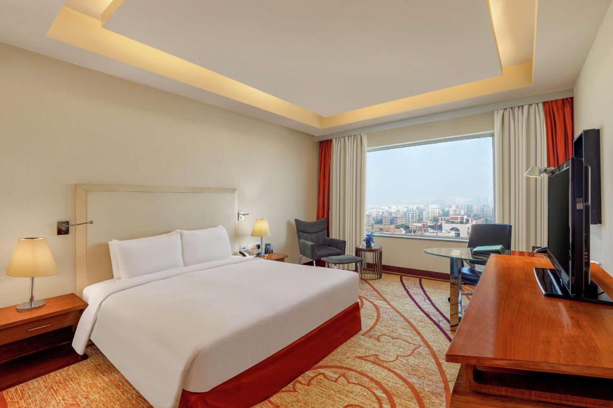 a hotel room with a bed and a desk and a television at DoubleTree by Hilton Gurgaon New Delhi NCR in Gurgaon