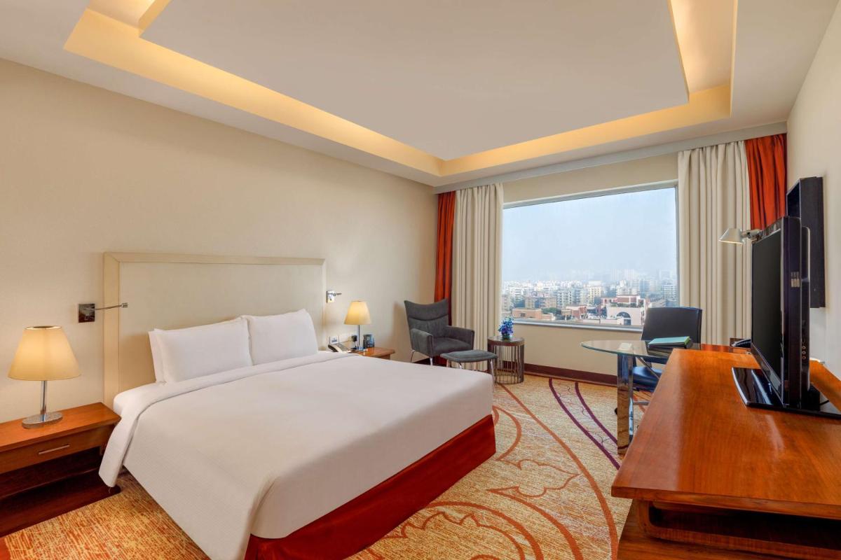 a hotel room with a bed and a desk and a television at DoubleTree by Hilton Gurgaon New Delhi NCR in Gurgaon