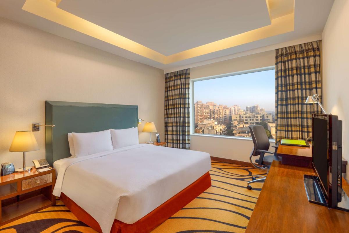 a hotel room with a bed and a large window at DoubleTree by Hilton Gurgaon New Delhi NCR in Gurgaon