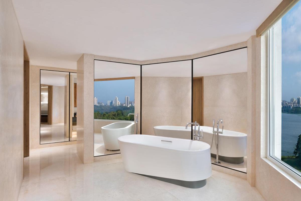 a bathroom with two sinks and a tub and windows at The Westin Mumbai Powai Lake in Mumbai