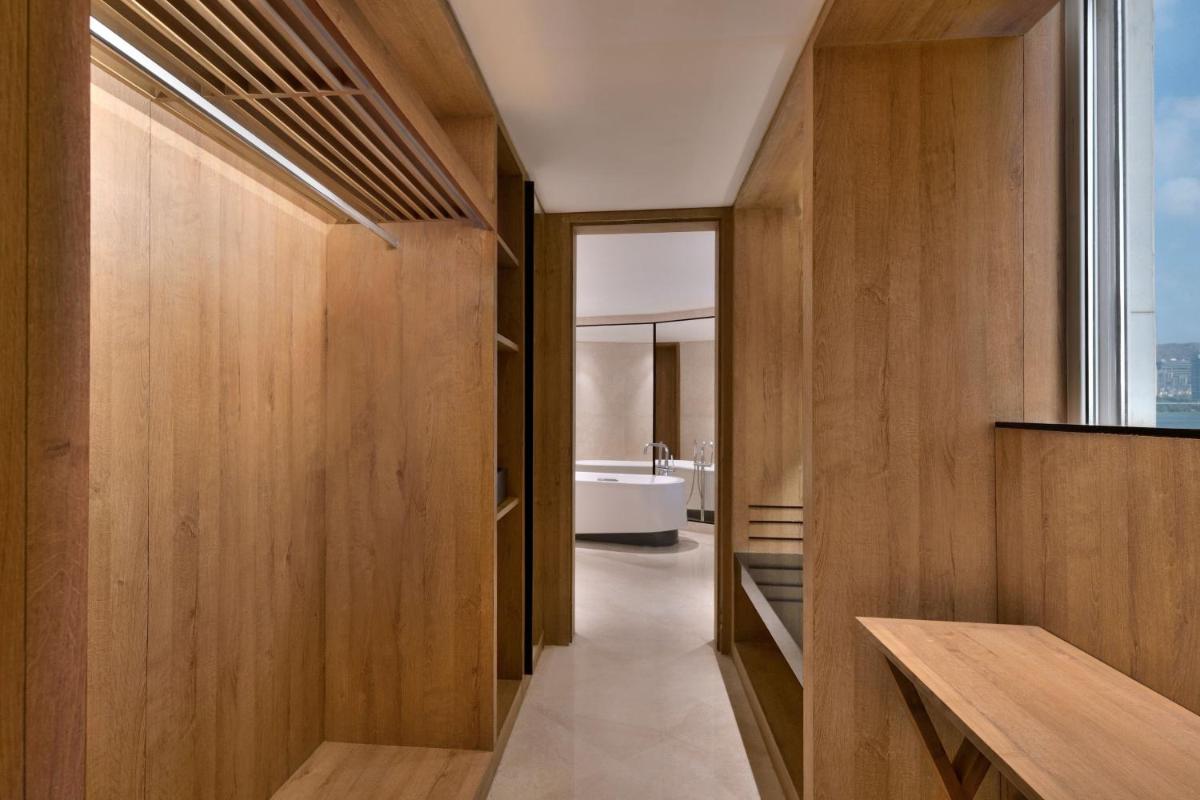 a bathroom with wood paneling and a bath tub at The Westin Mumbai Powai Lake in Mumbai