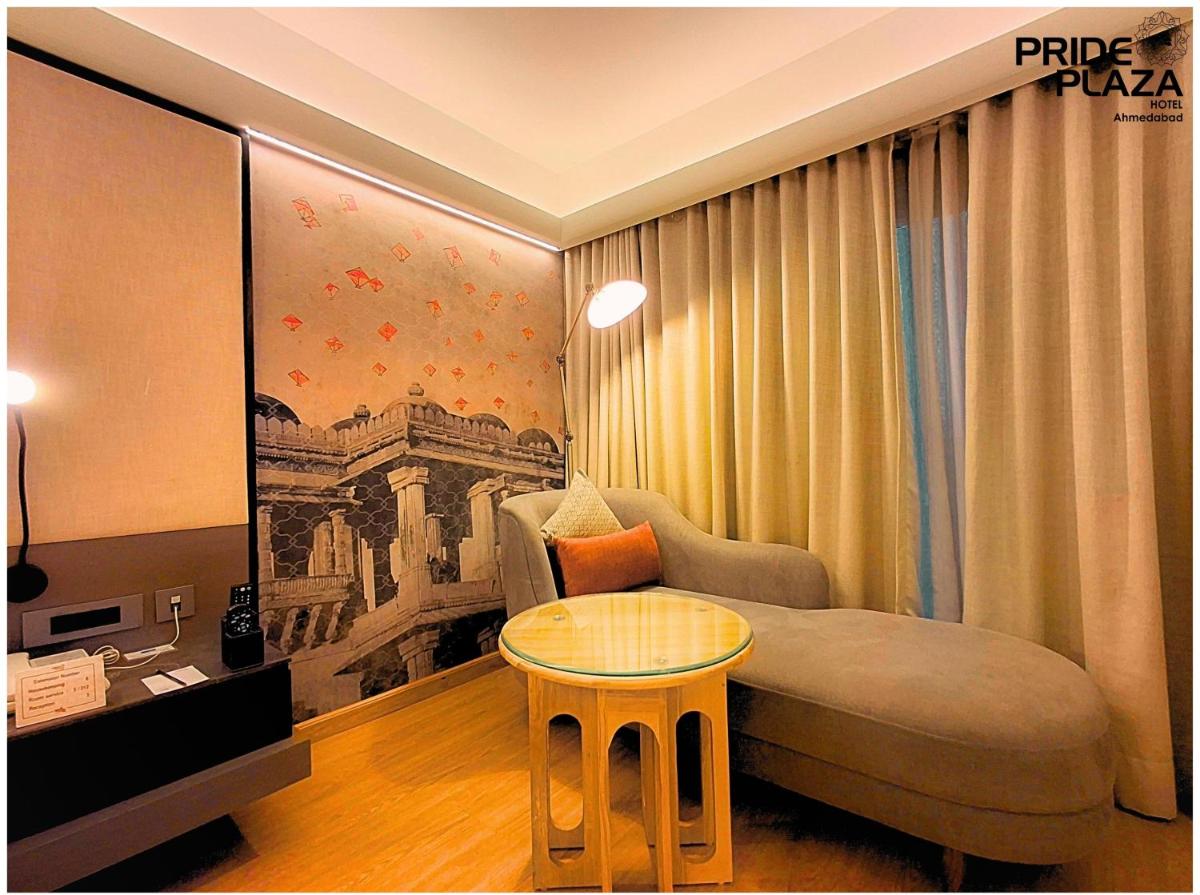a hotel room with a bed and a table at Pride Plaza Hotel, Ahmedabad in Ahmedabad