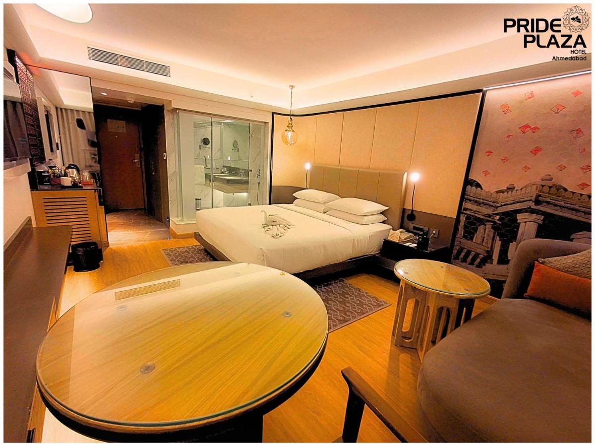 a hotel room with a bed and a table at Pride Plaza Hotel, Ahmedabad in Ahmedabad